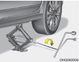 9. Insert the jack handle into the jack and turn it clockwise, raising the vehicle