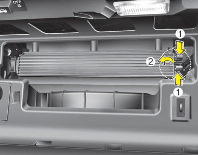 3. Remove the climate control air filter cover while pressing the lock on the